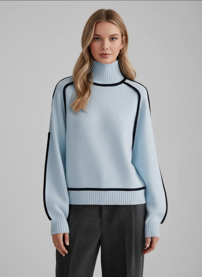 Woman wearing a light blue sweater with black accents on a gray background