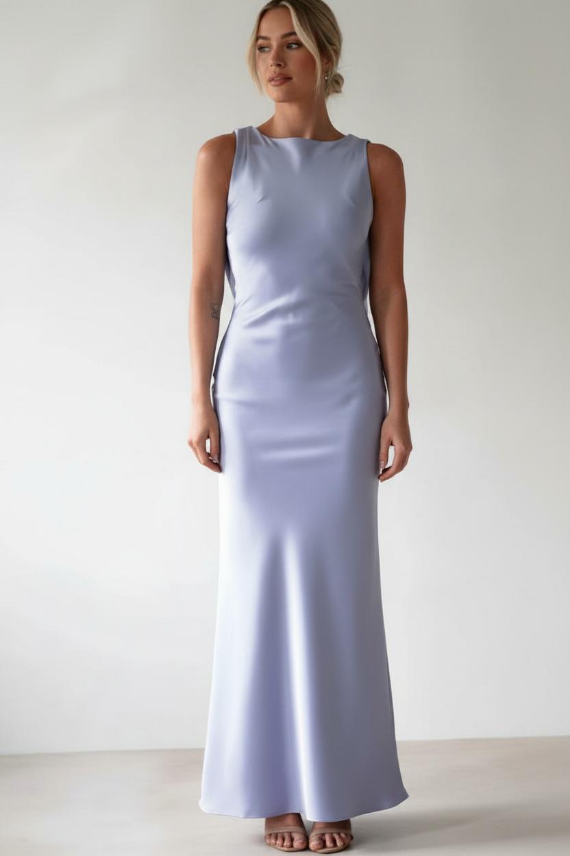 Woman wearing a light purple sleeveless gown against a plain background