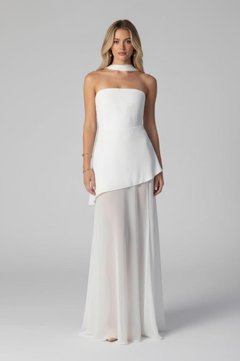 Woman wearing a strapless white top and beige skirt on a gray background