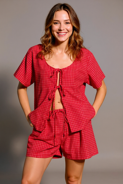 Woman wearing a red checkered outfit against a gray background