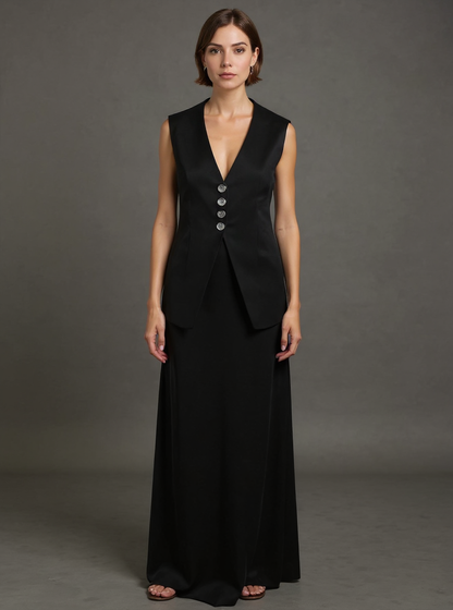 Woman wearing a black sleeveless dress with buttons on a gray background