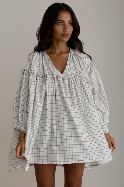 Woman wearing a checkered dress against a neutral background