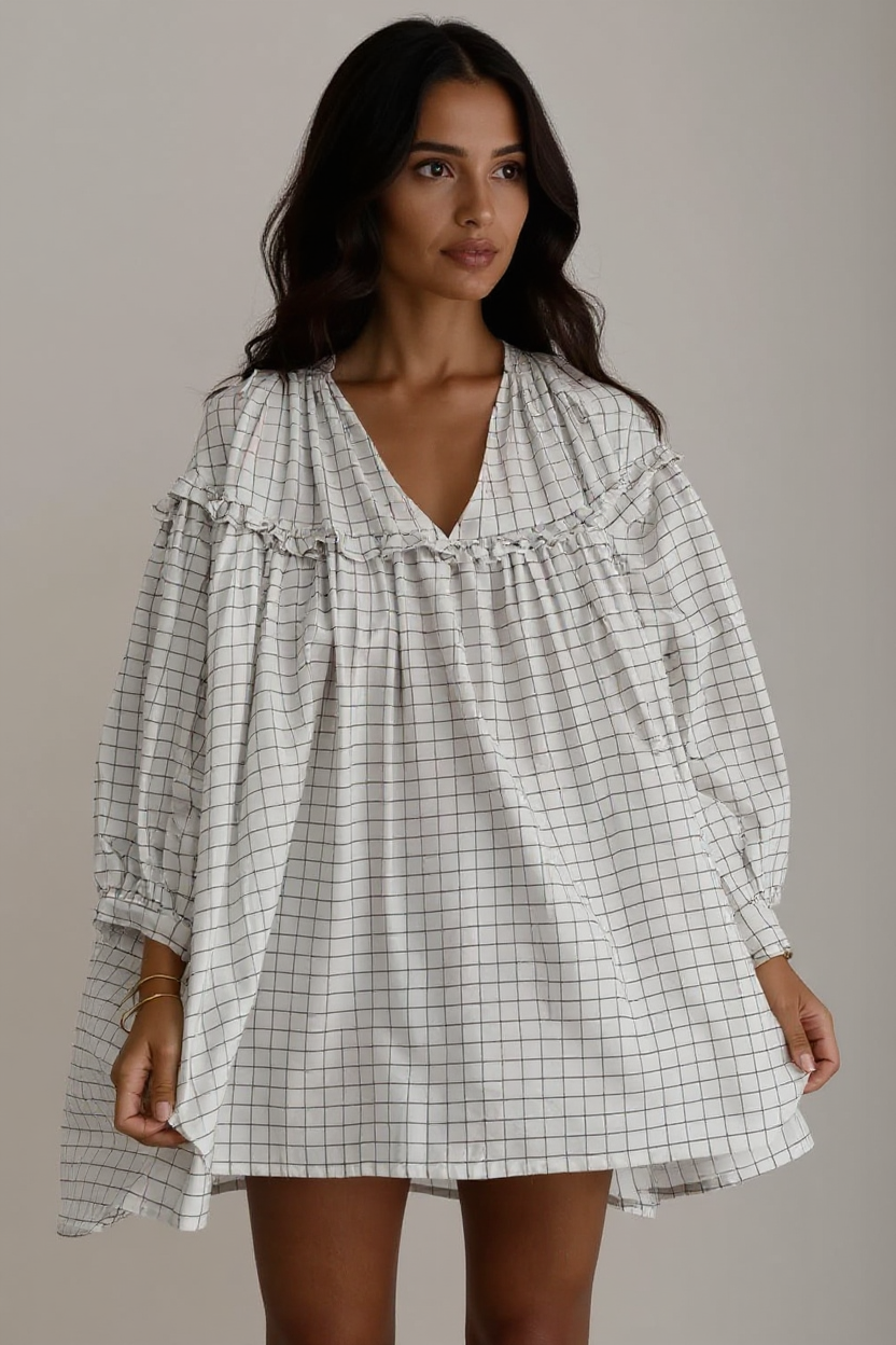 Woman wearing a checkered dress against a neutral background
