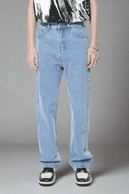 Person wearing light blue jeans and a black and white patterned shirt on a white background