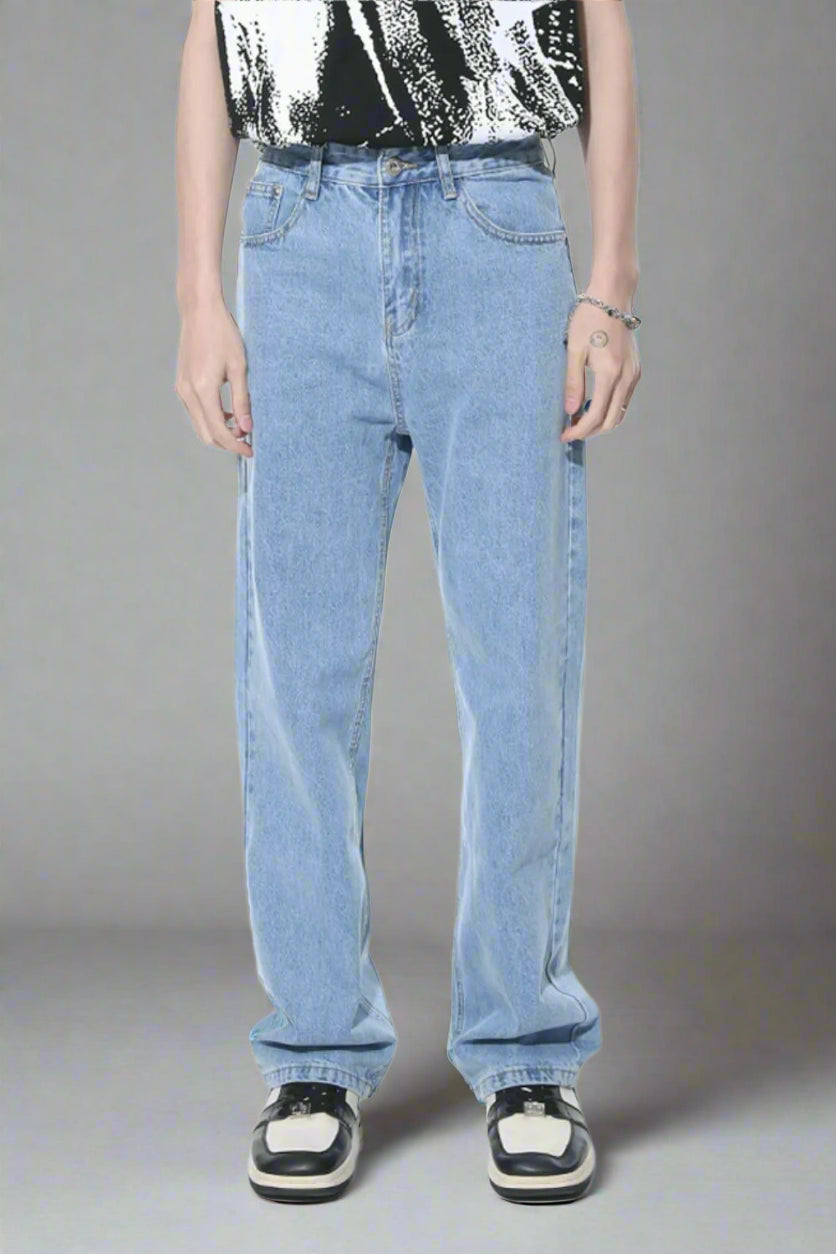 Person wearing light blue jeans and a black and white patterned shirt on a white background
