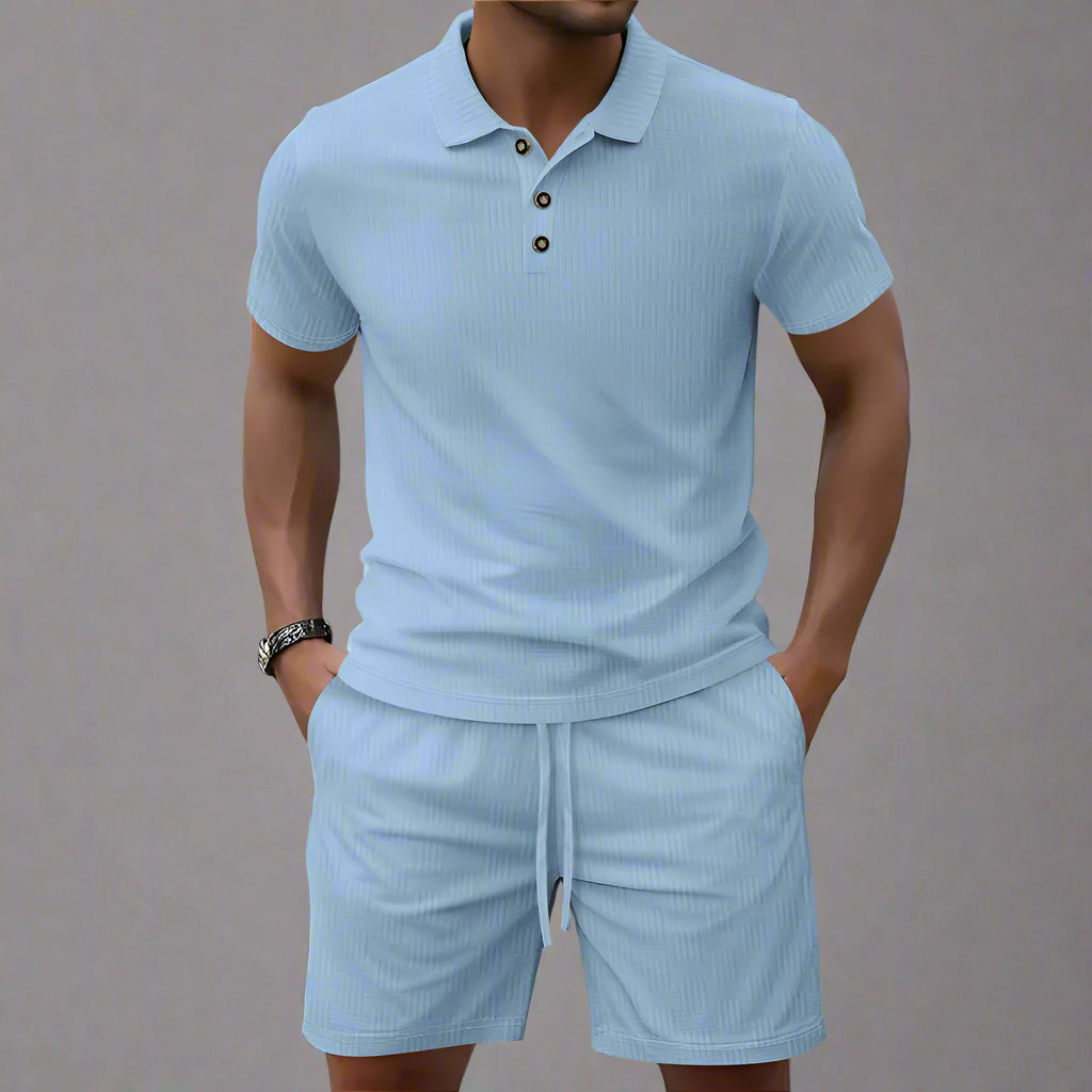 Man wearing a light blue polo shirt and shorts set on a blurred background