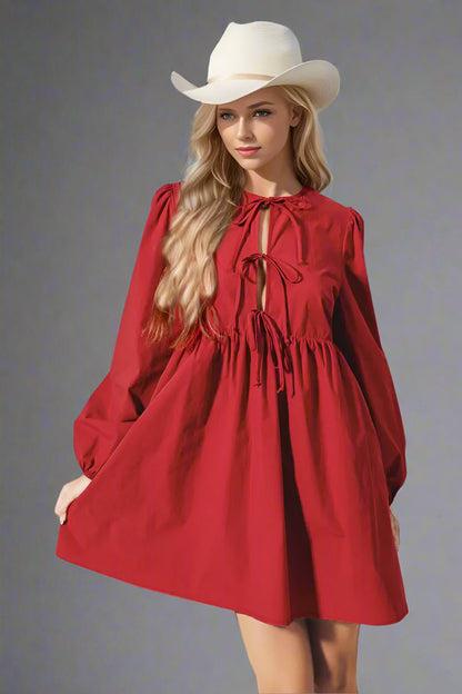 Woman wearing a red dress and white hat against a light background