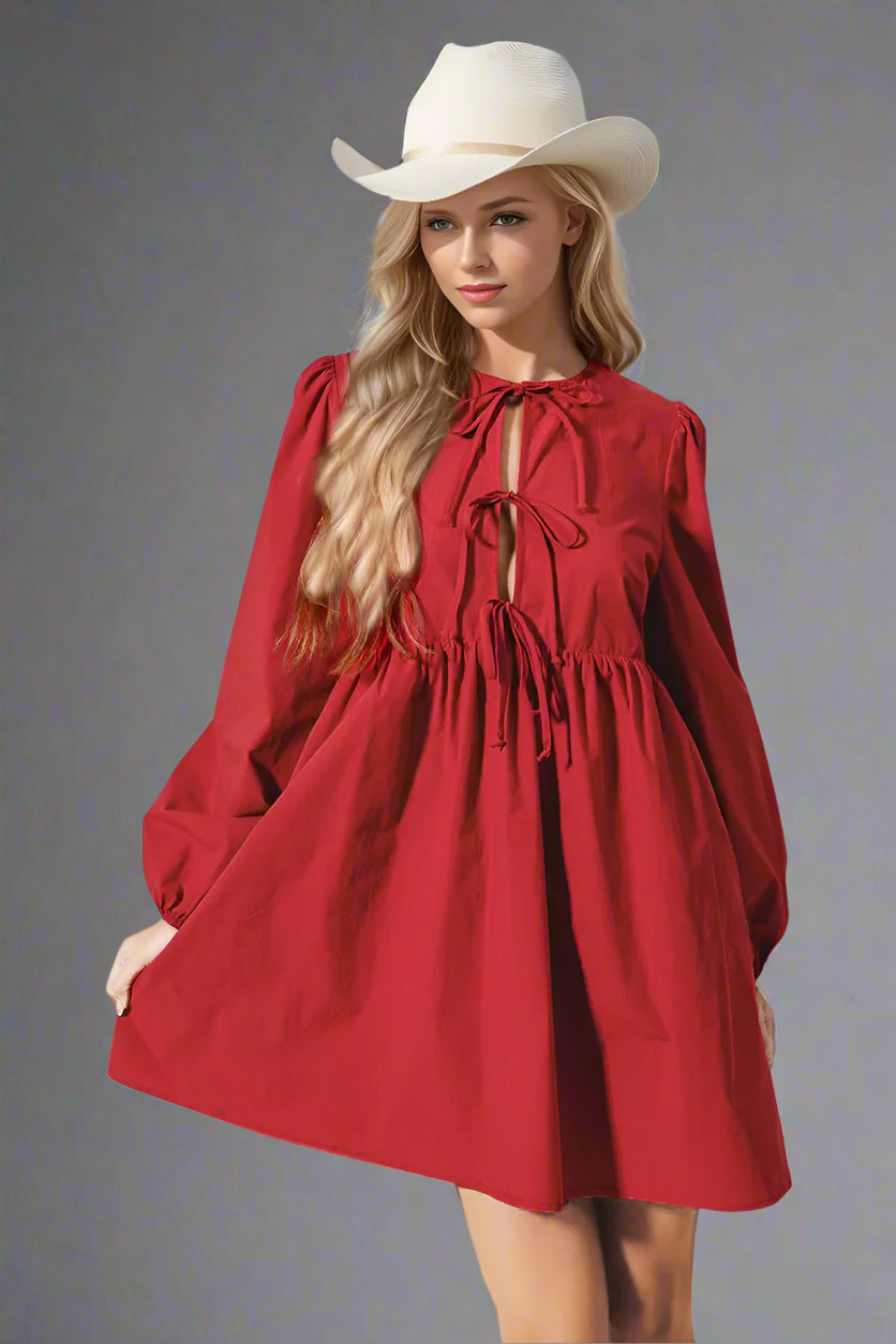 Woman wearing a red dress and white hat against a light background
