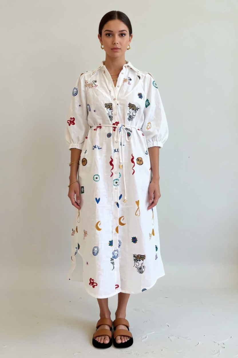 Woman wearing a white dress with colorful patterns on a plain background