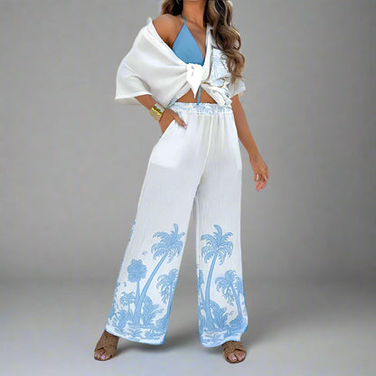 Woman wearing a white outfit with blue palm tree patterns in a bright setting