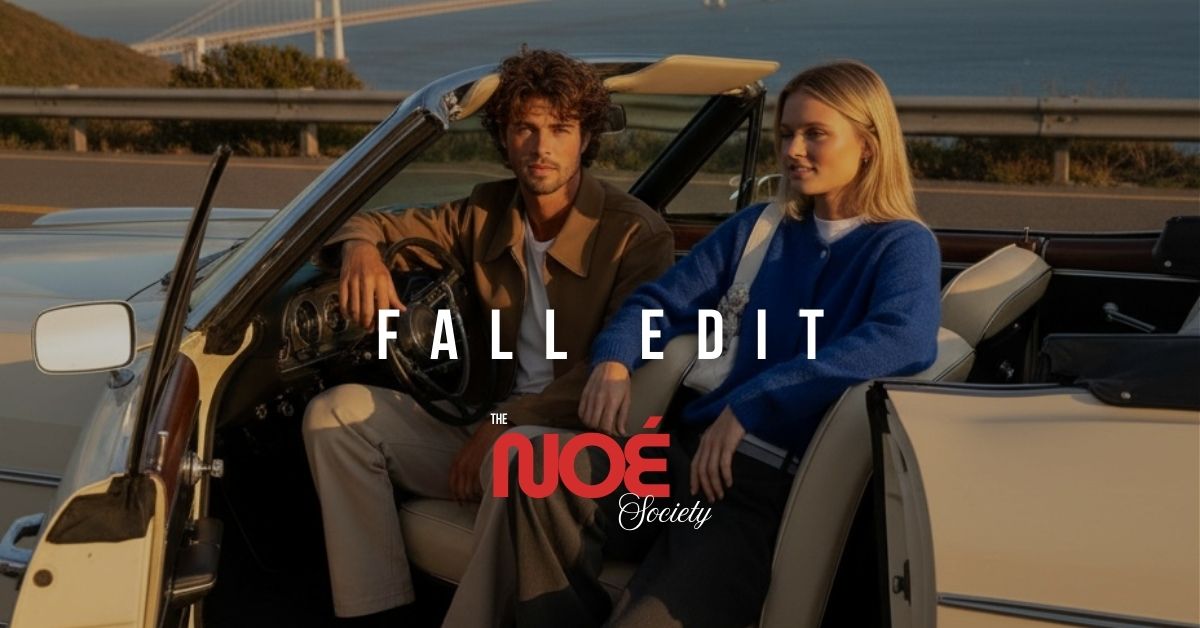 Two people sitting in a convertible car with 'The Nué Society' branding.